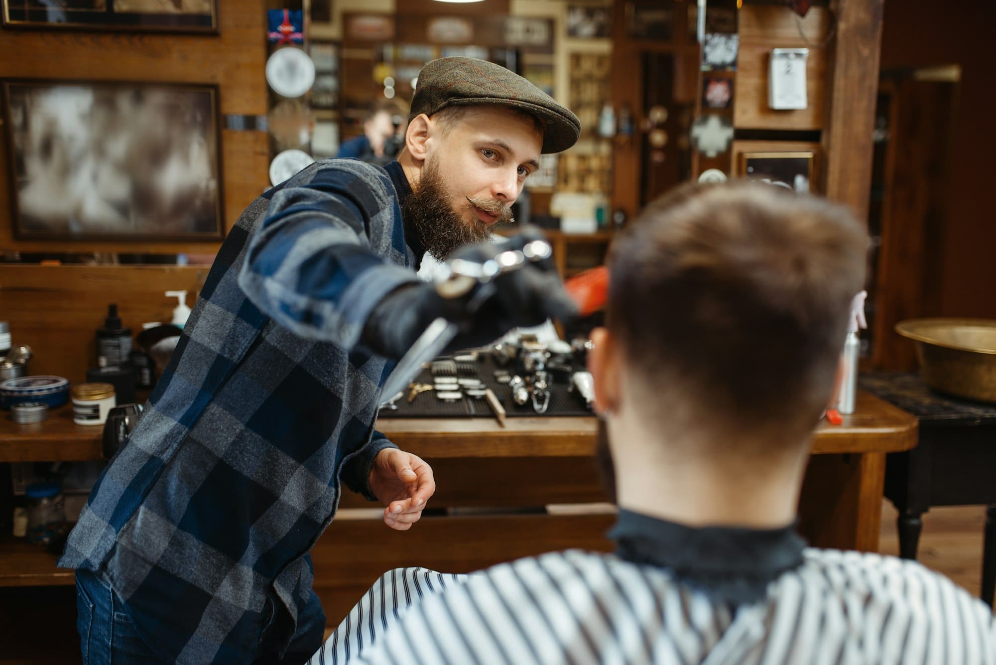 Barber makes a haircut to client, barbershop